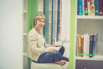 Symbolbild, sitzende Frau mit Laptop bzw. Büchern Symbolbild, sitzende Frau mit Laptop bzw. Büchern